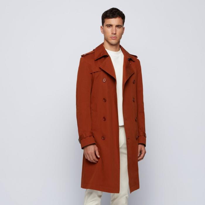 Model in light menswear and tan trench coat