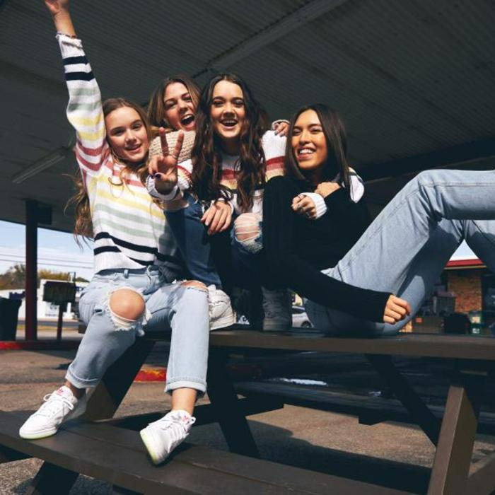 Gang of smiling girls on a picnic bench